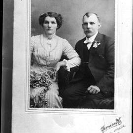 Studio portrait of a seated man and woman.