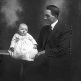 Studio portrait of Mr. C. Peterson and a baby.