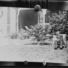 An unidentified man and woman in front of a brick Edwardian house.  Family name possibly Guppy.