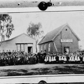 Pupils and teachers grouped outside two Benalla school buildings.