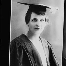 An unidentified young woman wearing an academic gown and mortarboard.