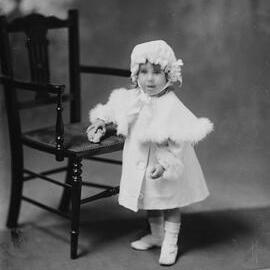 Portrait of an unidentified young girl wearing a bonnet and fur cape.