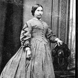 Studio portrait of an unidentified woman wearing a check dress.