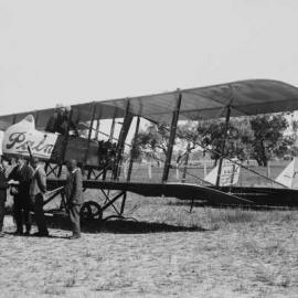 A pusher biplane aeroplane in a farmland environment.