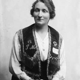Studio portrait of Miss E. Stewart wearing an embroidered vest.