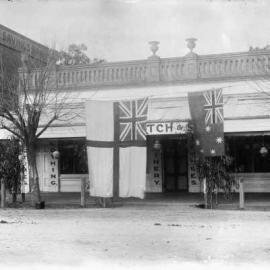 Flags displayed for peace celebrations in front of a drapery shop in Benalla.