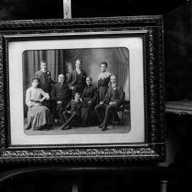 A posed group of eight unidentified people in a studio.