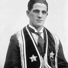 Studio portrait of Mr. D. Warne wearing a fringed vest.