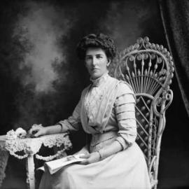 Studio portrait of a woman seated on a  wicker chair.  Family name Evans.