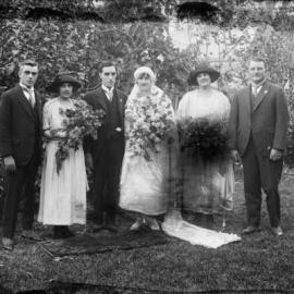 A wedding party of bride, groom and four others, in a garden environment, possibly in Benalla.