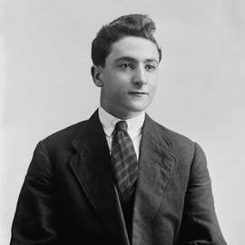 Studio portrait of a young man in a suit and wide striped tie.