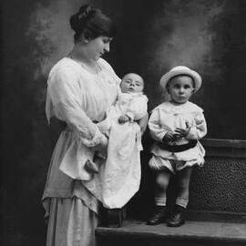 Studio portrait of a  woman  with two young children. Family name Eppas.