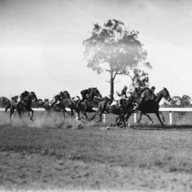 A horse race at an unidentified country racecourse.