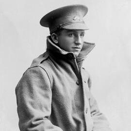 Studio portrait of a young man wearing a great coat and Australian Army cap.