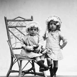 Studio portrait of  two girls wearing bonnets.  Family name Hocking.