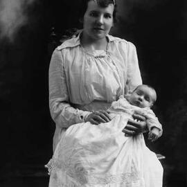 Studio portrait of a young woman holding a baby.  Family name Gladstone.