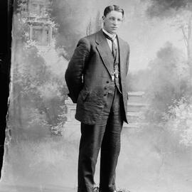 Studio portrait of a man wearing a crumpled suit.  Family name possibly Lee.
