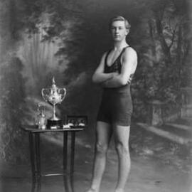Studio portrait of a young sportsman with medals and trophies.  Family name Noonan.