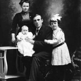 Studio portrait of two adults and two children.  Family name Allen.