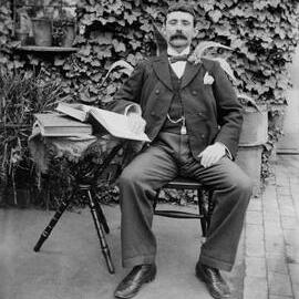 Outdoor portrait of an unidentified seated man.