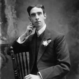 Studio portrait of a young man seated sideways on a chair.  Family name Richardson.