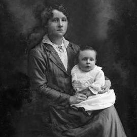 Studio portrait of Miss Johnson holding a baby.
