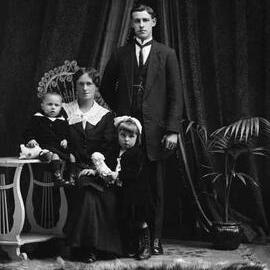 Studio portrait of a woman, man and two young children.   Family name Smith.
