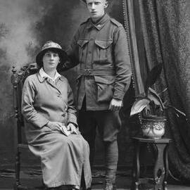 Studio portrait of a woman with a man in an Australian Army uniform.