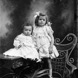 Studio portrait of a young girl and a baby.  Family name Lynch.