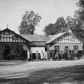 A group of men and cars outside the Tatong Hotel, Tatong.