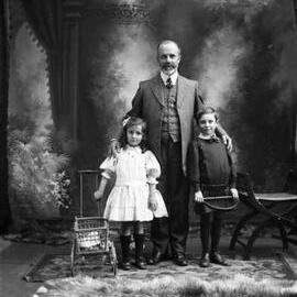 Studio portrait of a man and two children.  Family name Hiscock.