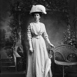 Studio portrait of a woman wearing a large feathered hat.  Family name Evans.