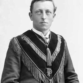 Studio portrait of Mr Flannery wearing a velvet vest.