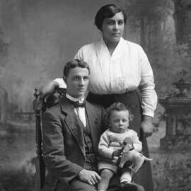 Studio portrait of a man, a woman and a baby.  Family name Garbutt.