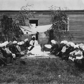 A group of Indian men, possibly Sikhs, outside a timber cottage at Reef Hills near Benalla.