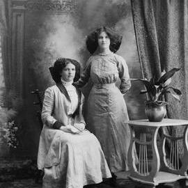 Studio portrait of two young women with flamboyant hair styles.