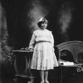 Studio portrait of a girl wearing a large bow.