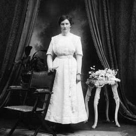 Portrait of an unidentified woman wearing a long white dress.