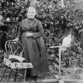 An elderly woman with a crested cockatoo.