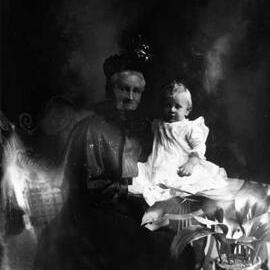 Studio portrait of an elderly woman supporting a baby.  Family name Chaffy.