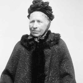 Studio portrait of Mrs. Quinn wearing a brocade fur-trimmed jacket.