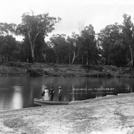 A woman and two men fishing at the Murray River, Victoria.