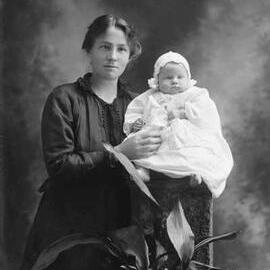 Studio portrait of Mrs. Donahoo with a baby.