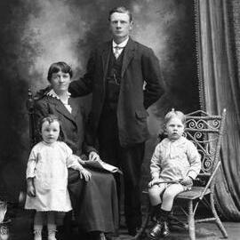 Studio group portrait of a woman and man with a boy and girl.  Family name Dixon.