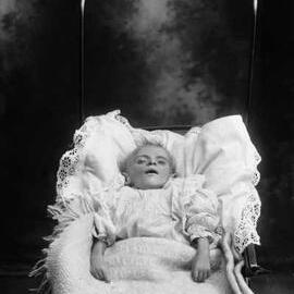 Portrait of young child lying in a pusher.