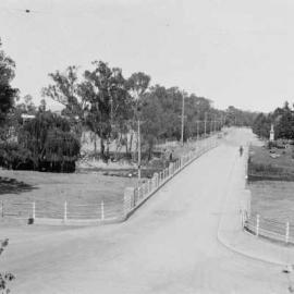 A view, looking West, of the concrete road bridge and the Broken River at Benalla.