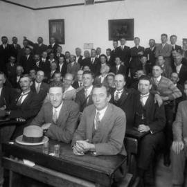 A group of men in a school classroom.