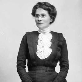 Studio portrait of an unidentified woman wearing spectacles.