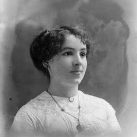 Studio portrait of an unidentified young woman wearing a white blouse.