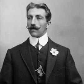 Studio portrait of a young man with a handle-bar moustache.  Family name possibly Knorr.